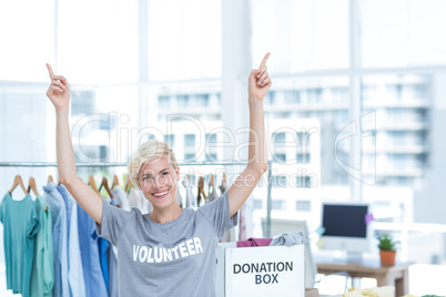 Happy blonde volunteer pointing up