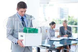 Businessman carrying his belongings in box