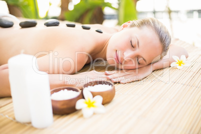 Beautiful woman receiving stone massage at spa center