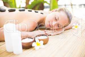 Beautiful woman receiving stone massage at spa center