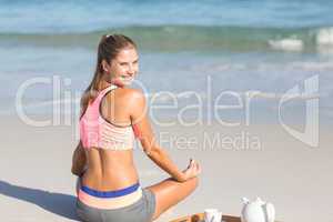 Fit woman doing yoga beside the sea