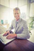 Smiling businessman in his laptop