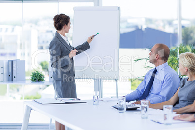 Business people looking at meeting board during conference