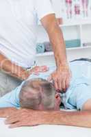 Physiotherapist doing neck massage to his patient