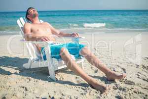 Man relaxing on deck chair at the beach