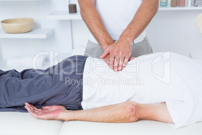 Physiotherapist doing back massage to his patient