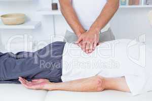 Physiotherapist doing back massage to his patient