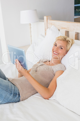 Portrait smiling blonde woman using digital tablet