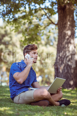 Hipster using laptop in the park