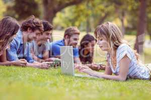 Pretty blonde using laptop in the park