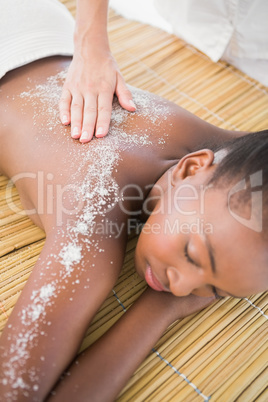 Pretty woman enjoying a salt scrub massage