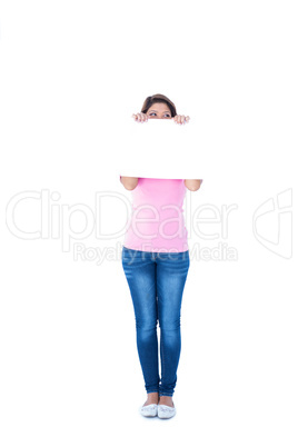 Pretty brunette holding blank sign in front of her head