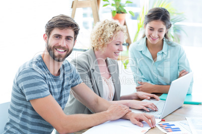 Colleagues using laptop at office