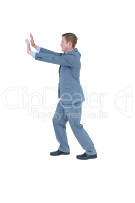 Businessman standing and pushing with hands