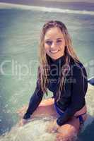 Woman on a surfboard smiling at camera