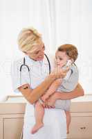 Smiling blonde doctor with child and stethoscope