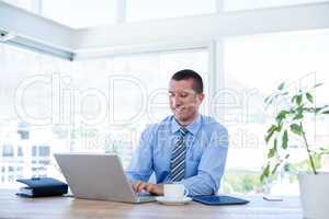 Smiling businessman working with his laptop