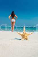 Pretty brunette and starfish on the beach