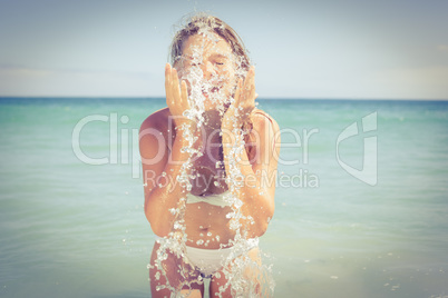 Pretty blonde refreshing her face with water