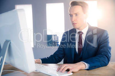 Serious businessman typing on computer