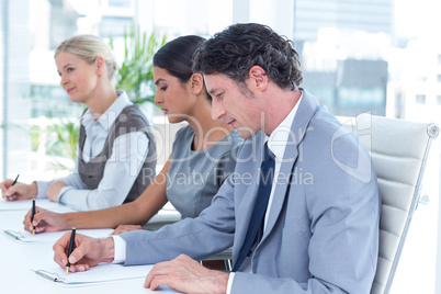 Group of business people taking notes
