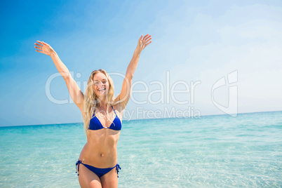 Smiling blonde woman walking into the ocean