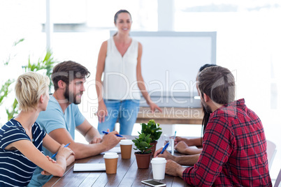 Casual businesswoman giving presentation to her colleagues