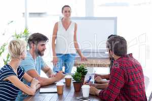 Casual businesswoman giving presentation to her colleagues