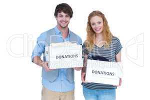 Smiling young couple carrying donation box