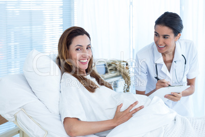 Smiling pregnant woman with her doctor