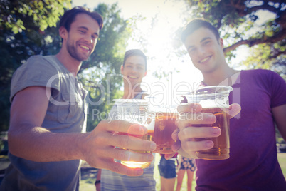 Happy friends in the park having beers