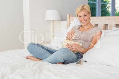 Portrait smiling blonde woman eating pop corn