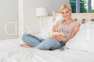 Portrait smiling blonde woman eating pop corn