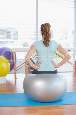 Woman sitting on exercise ball Woman sitting on exercise ball