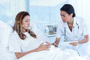 Unsmiling pregnant woman with her doctor