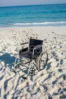 Black wheelchair on the beach