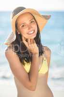 Brunette relaxing with a straw hat smiling at camera