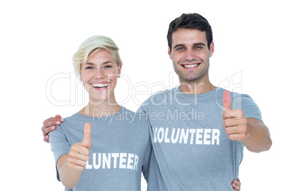 Couple of young volunteers gesturing thumbs up