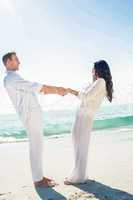 Couple holding hands and standing at beach