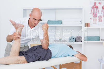 Physiotherapist doing leg massage to his patient