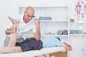 Physiotherapist doing leg massage to his patient