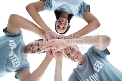 Happy volunteers putting their hands together