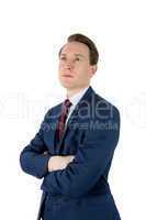 Thoughtful businessman looking away with arms crossed