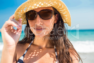 Pretty brunette looking at camera at the beach