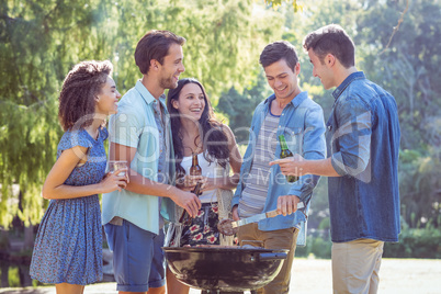 Happy friends in the park having barbecue