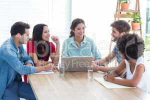 Colleagues using laptop at office