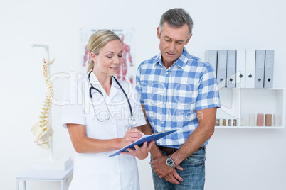 Doctor showing clipboard to her patient