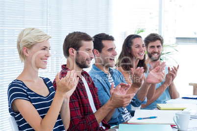 Colleagues clapping hands in meeting