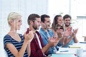 Colleagues clapping hands in meeting