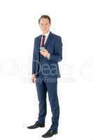 Businessman holding his smartphone and looking at camera